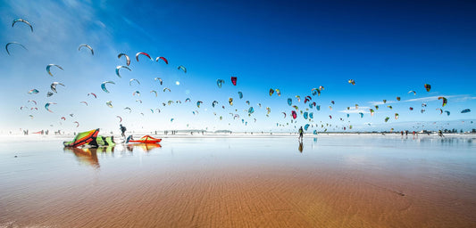 Landscape photo with lots of kites in the sky.